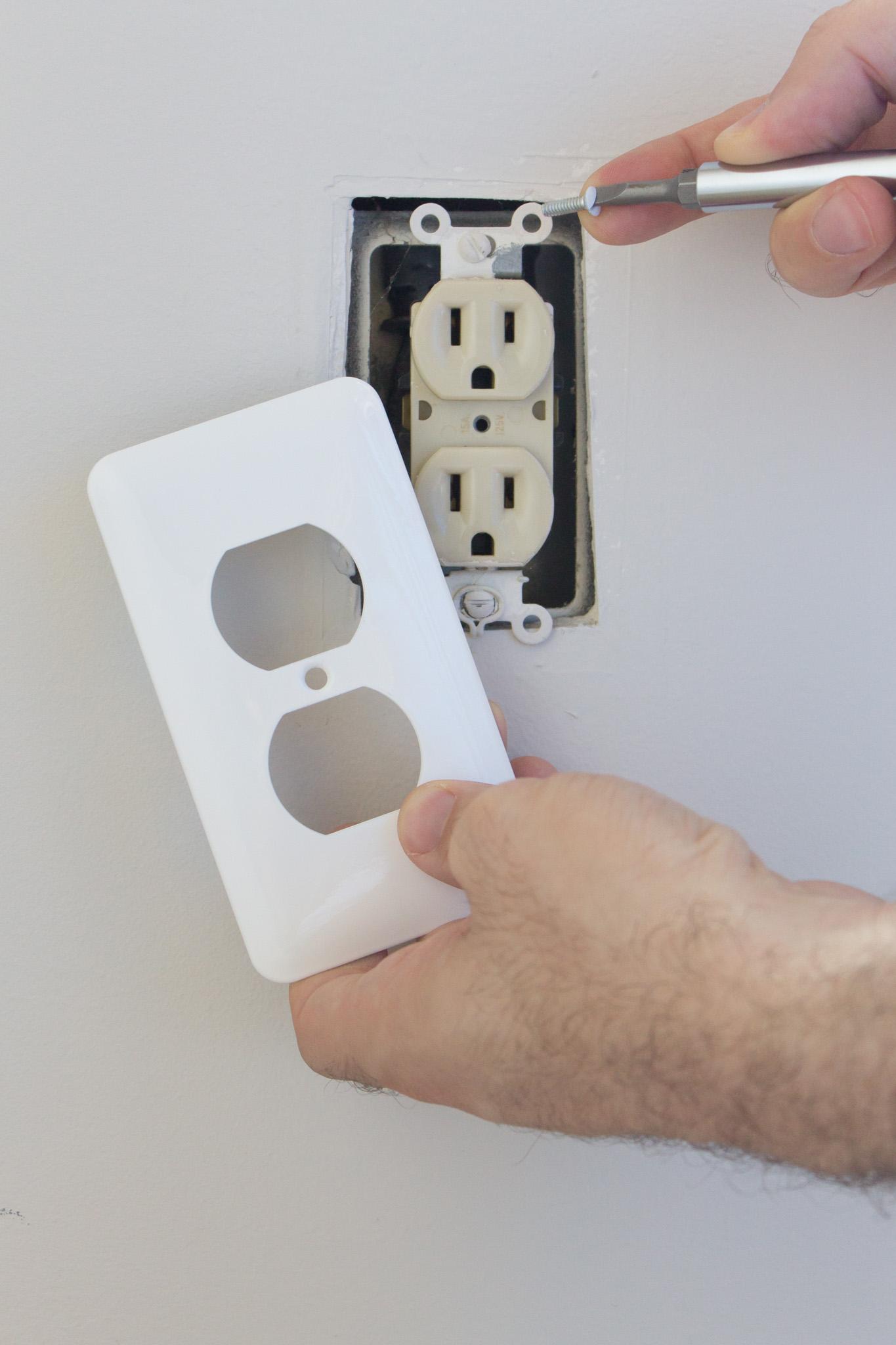 An electrician repairing an outlet - WyattWorks offers professional elecrical services in Cleveland, OH.