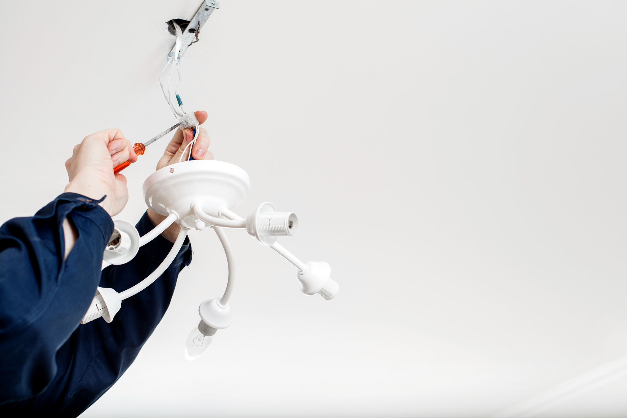 An electrician providing installation services for lighting - get professional services today with WyattWorks Cleveland.