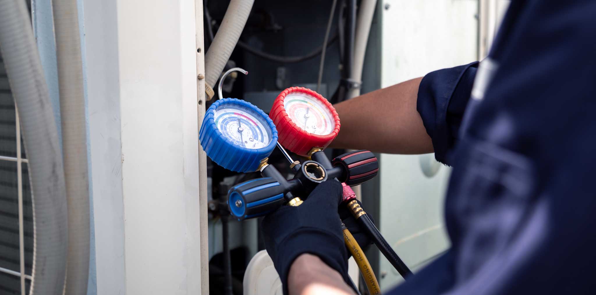 An image of a technician using a gauge on HVAC systems.