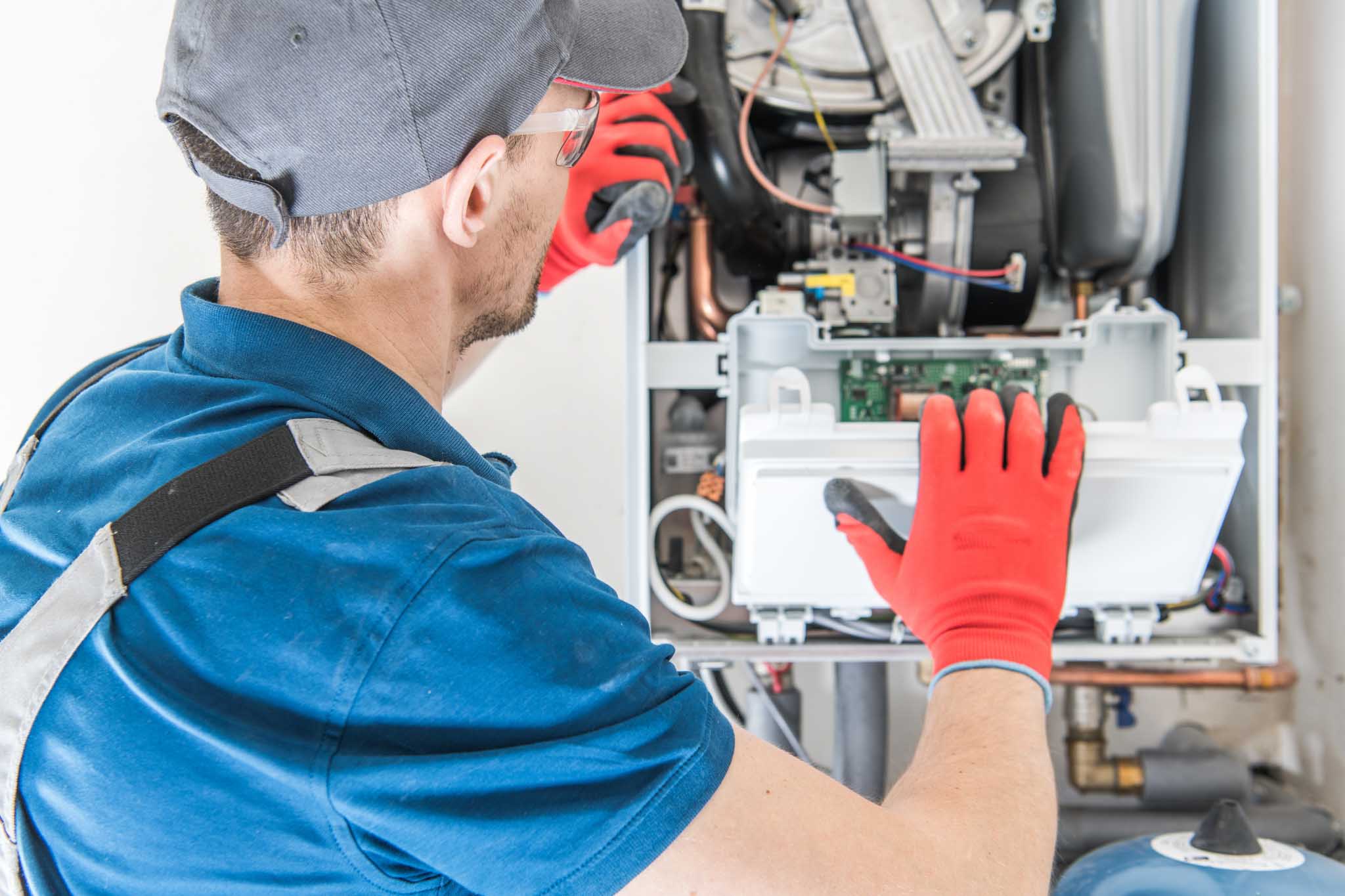 An imag of a gas furnace being serviced by a professional technician.
